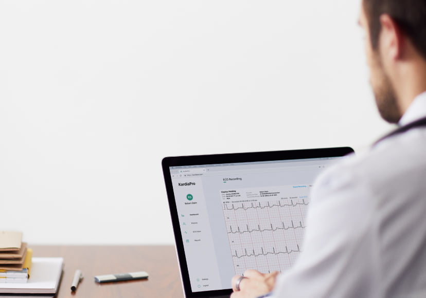 Doctor looking at laptop with KardiaPro open reviewing an ECG